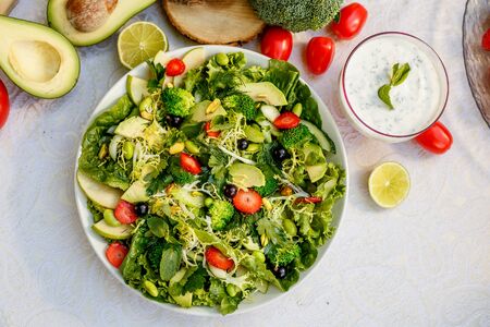 Detox, healthy vegetable salad with broccoli and avocado, healthy food on a decorated tableの写真素材