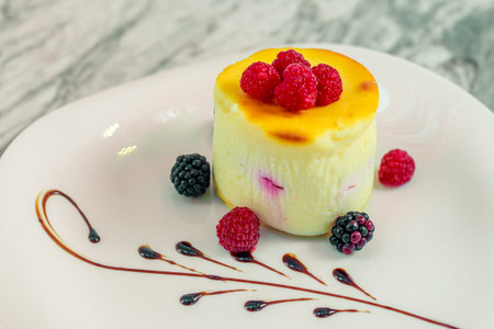 delicate cheesecake with berry mix on a white plateの写真素材