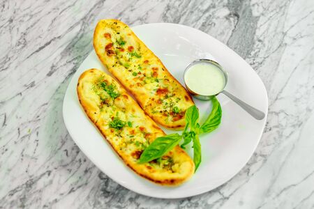 Garlic bread with cheese and herbs with sauce. Beautiful pitchの写真素材