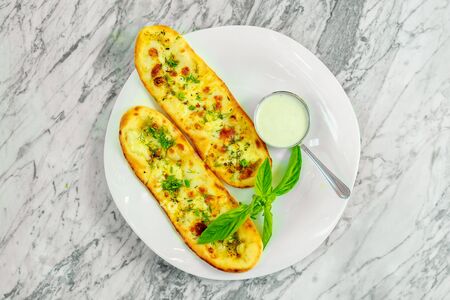 Garlic bread with cheese and herbs with sauce. Beautiful pitchの写真素材