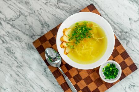 soup with chicken, mushrooms and herbs on a white plate, a beautiful servingの写真素材