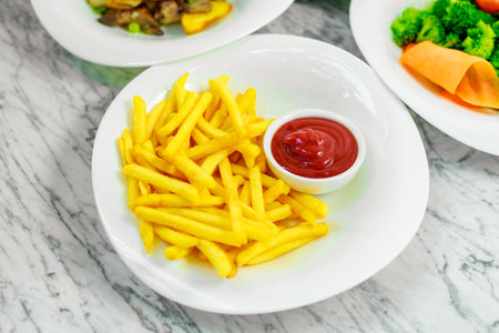 side dishes for the main course,potato fries with ketchup on a white plate, beautiful serve
