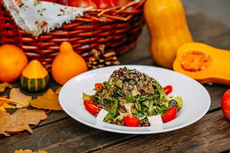 Autumn table setting with pumpkins. Thanksgiving dinner. vegetarian salad with tomatoes and cheese. Healthy foodの写真素材