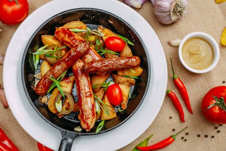Autumn table setting with pumpkins. Thanksgiving dinner. sausages with fried potatoes in a panの写真素材