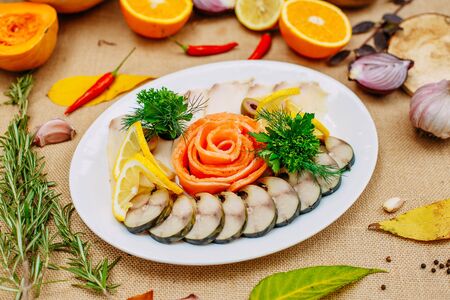 Autumn table setting with pumpkins. Thanksgiving dinner. fish platter with lemon in a white plateの写真素材