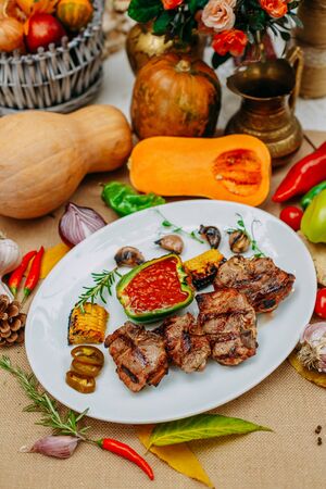 Autumn table setting with pumpkins. Thanksgiving dinner.grilled meat with vegetablesの写真素材