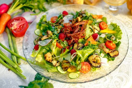Fresh salad with dried meat, herbs and vegetables served on the table with the ingredients, healthy foodの写真素材