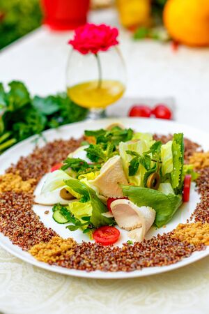 salad with red quinoa and chicken breast with tomatoes served on the table with ingredients, healthy foodの写真素材