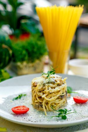 Italian pasta carbonara served on a table with ingredientsの写真素材