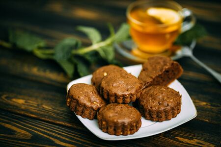 homemade cakes, chocolate muffins with mint and tea with lemonの写真素材
