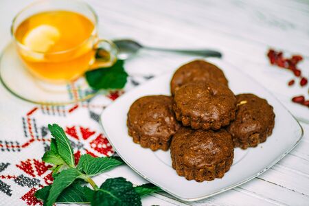 homemade cakes, chocolate muffins with mint and tea with lemonの写真素材