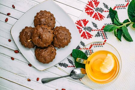 homemade cakes, chocolate muffins with mint and tea with lemonの写真素材