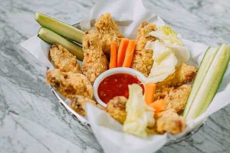 chicken nuggets with sauce and vegetables on a marble tableの写真素材
