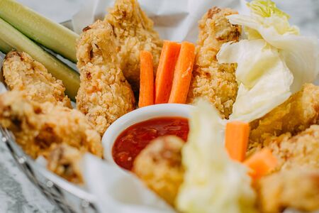 chicken nuggets with sauce and vegetables on a marble tableの写真素材