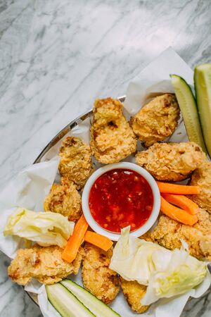 chicken nuggets with sauce and vegetables on a marble tableの写真素材