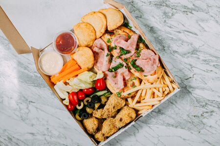 cold cuts with vegetables on a marble tableの写真素材