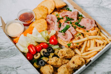 cold cuts with vegetables on a marble tableの写真素材