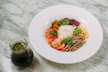 ingredients for cooking Korean kuksi in a white plate on a marble tableの写真素材