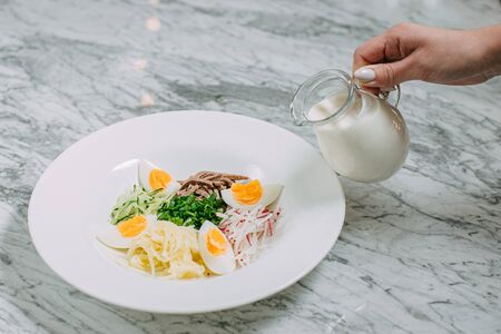 ingredients for cooking russian okroshka dish in a white plate on a marble tableの写真素材
