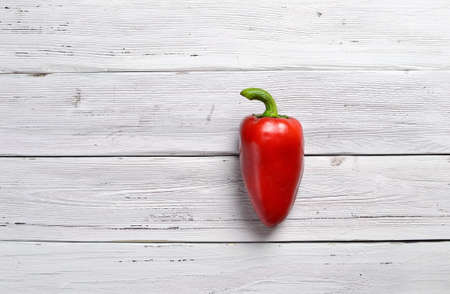one red pepper paprika on old rustic white wooden tableの写真素材