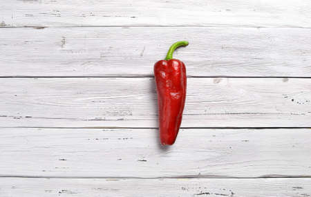 one red pepper chili on old rustic white wooden tableの写真素材