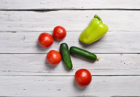 still life with tomatoes, cucumbers, pepper on an old wooden light rustic tableの写真素材