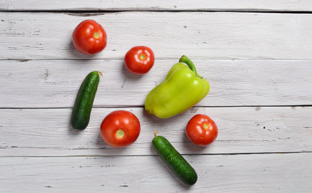 still life with tomatoes, cucumbers, pepper on an old wooden light rustic tableの写真素材