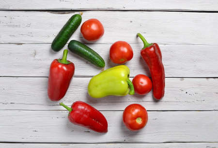 top view of vegetables with tomatoes, cucumbers, pepper on an old wooden light rustic tableの写真素材