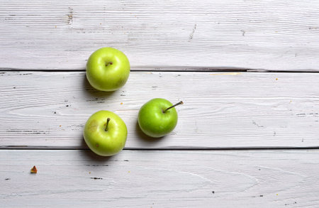 three red apples on white rustic wooden background, top view, copy spaceの写真素材