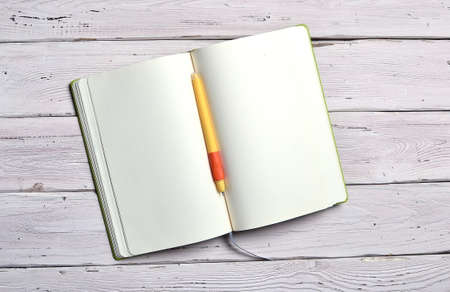 flat lay with open notebook with blank white pages and a pen for notes isolated on white wooden rustic backgroundの写真素材
