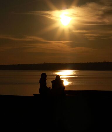 Two girls in the sunset near the riverの写真素材