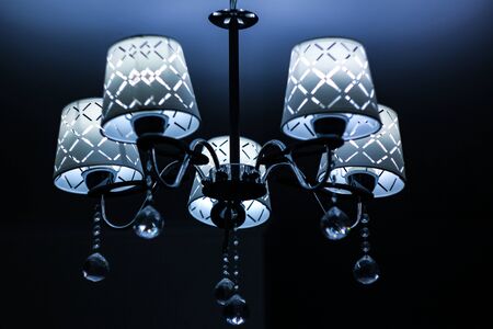 White lamp with silver base on the ceiling with deep shadowsの写真素材