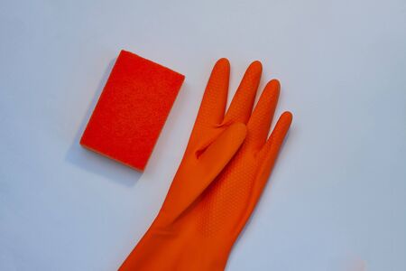 One orange glove for cleaning with an orange wisp on a grey backgroundの写真素材