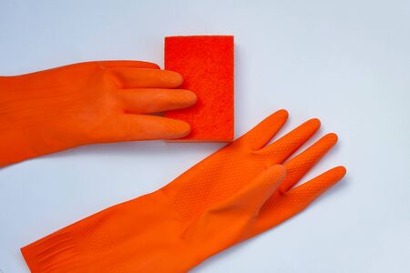 2 orange gloves for cleaning with an orange wisp on a grey background  の写真素材