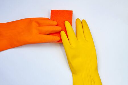 orange and yellow gloves for cleaning with an orange wisp on a grey background  の写真素材