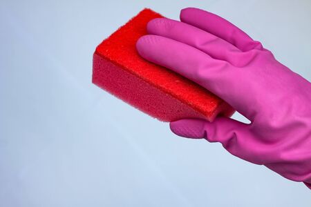 crimson glove for cleaning with a red wisp on a light background with a copy spaceの写真素材