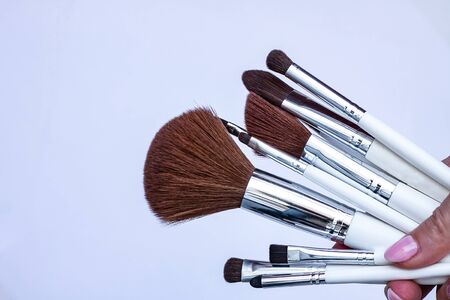 Set of makeup brushes  on a light background in a girl's hand with a copy spaceの写真素材