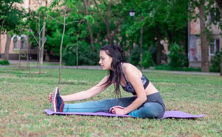 Beautiful  brunette is doing stretching  in the park. Concept of sport の写真素材