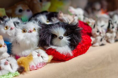 Many little fluffy creatures in a red wicker basket on the souvenir counter.  The sun shines brightly   in summer. Many tourists buy animal souvenirs in the zoo.の写真素材