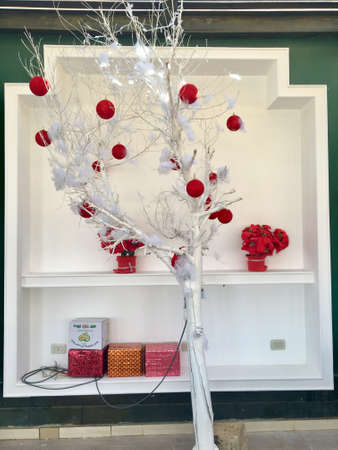 The idea of ââa Christmas tree in a hot country is very interesting. A tree branch painted with white paint, decorated with a white fluffy garland and red toy ballsの写真素材