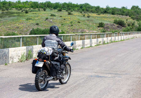 motorcyclist rides on the road in overalls in the hot summerの写真素材