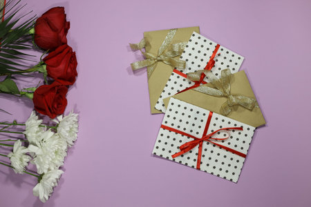 red roses, white flowers with gift envelope, red ribbon, certificate, invitation inside. Craft...