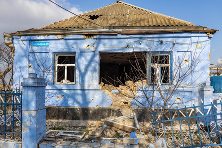Barmashovo, Ukraine- March 18, 2022: War of Russia against Ukraine. Concept of Russian invasion. Ruined and damaged house in the center of the village after bomb explosion throughのeditorial素材