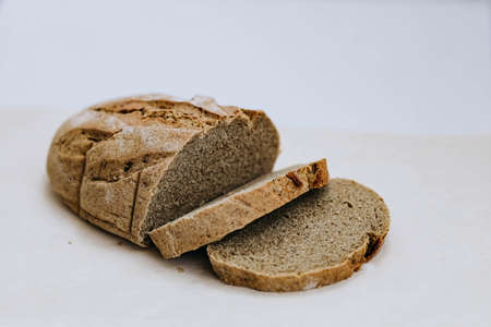 Homemade freshly baked rye and wheat loaf of bread on white background. Concept of health and huger. Organic food concept, photo with copy space, close upの写真素材