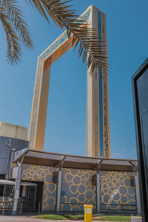 Dubai Frame the golden tower building at sunset. Dubai's famous modern architecture on a cloudy blue sky background. Architectural landmark in Zabeel Park. The biggest golden frame on the planetの写真素材