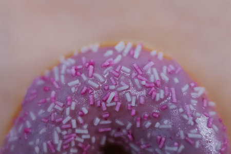 The Fully Close-up Of The Donut With Violet Icing And Colored Sprinkles. topView. Tasty delicious fat high calories sweet food. selective focus. favorite childhood treat. advertising banner.の写真素材