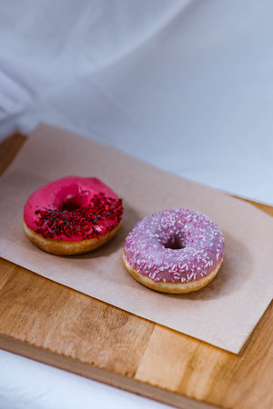 The Fully Close-up Of The Donuts With Pink and violet Icing And Colored Sprinkles with poppy seeds....