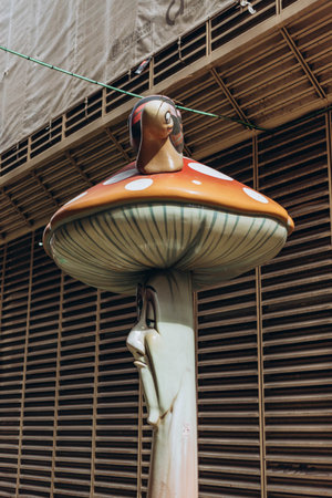 Alicante, Spain - May 16, 2023: One statue with ant at funny street Calle de Las Setas (The Mushroom Street) in Alicante old town. Fly agaric (or amanita muscaria) mushrooms creative street design.のeditorial素材