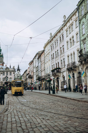 Lviv, Ukraine- May 13, 2023: Street scene in Lviv in Western Ukraine, with traditional buildings next to the pavement. Architecture that fascinates, tram and people walking outside. old city centerのeditorial素材