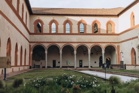 Milan, Italy- May 13, 2023: Inner courtyard view, Castello Sforzesco ancient monument, green lawn of courtyard, blue sky white clouds background,のeditorial素材